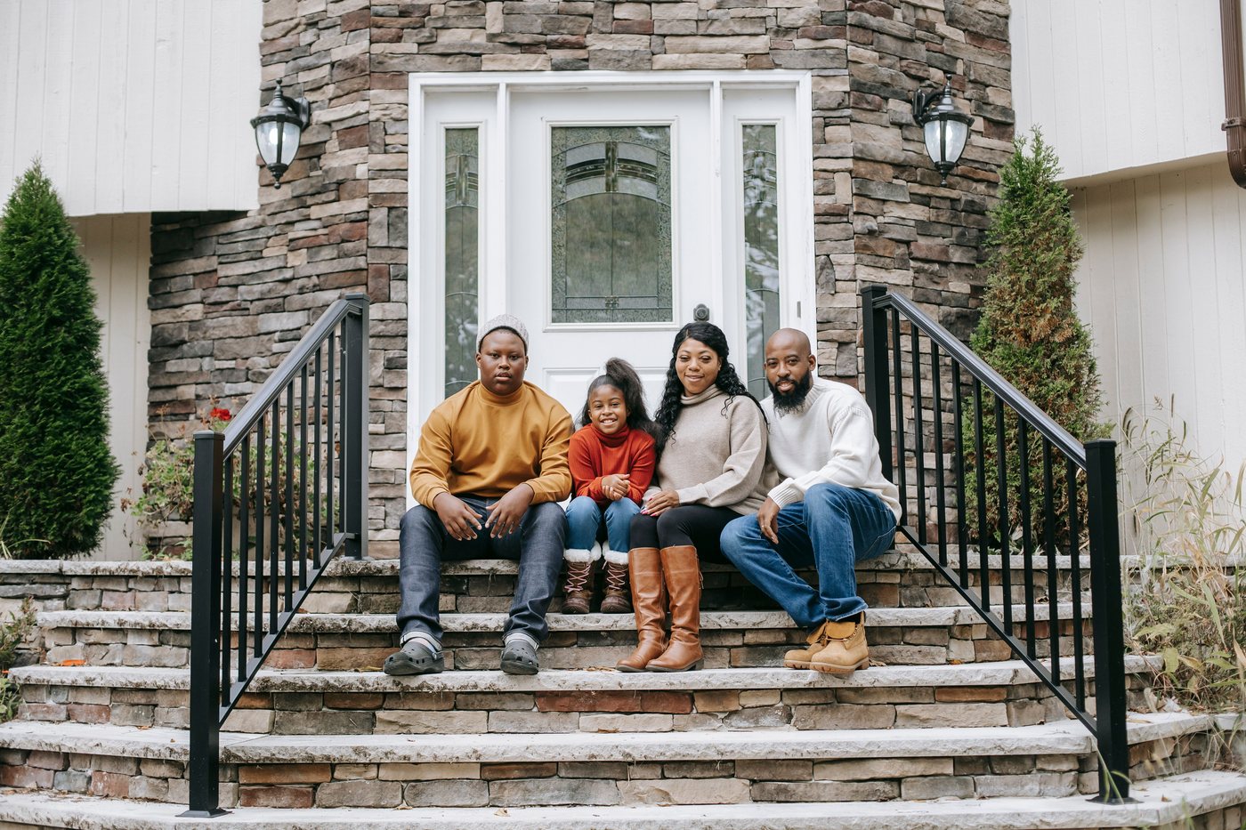 A family sitting together on the front steps of their house